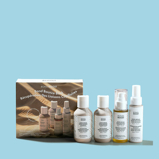 A collection of hair care products including a shampoo, conditioner, and treatment bottles, with packaging displayed in the background.