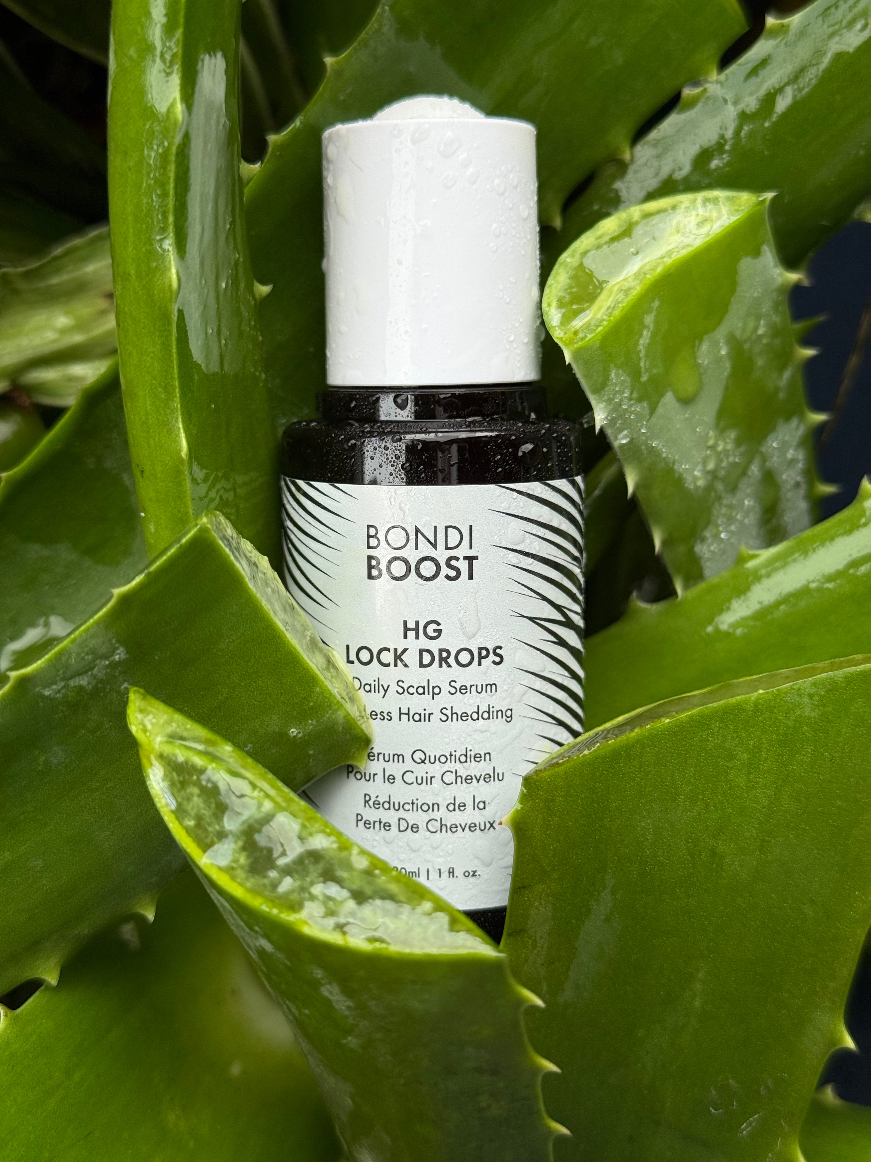 Bottle of Bondi Boost serum on a green leafy background